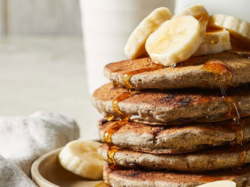 Gluten-Free Chocolate Chip Pancakes made with buckwheat flour and drizzled with maple syrup and banana slices