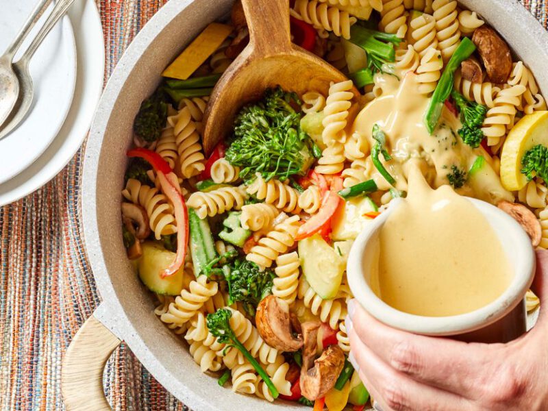 One-Pan Creamy Pasta with Broccolini with a creamy sauce being poured over it