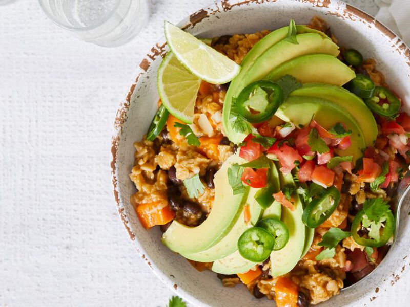 Southwestern Savory Oatmeal topped with avocado and salsa in a white bowl