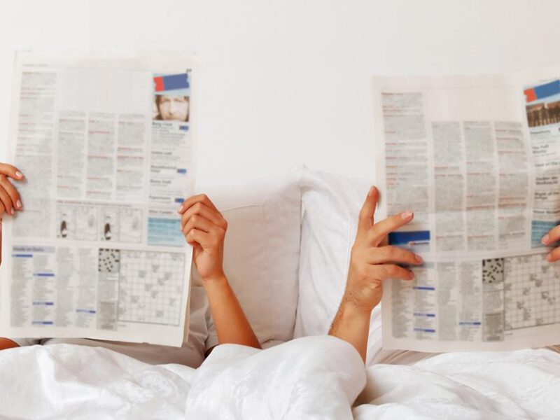 Erectile dysfunction - couple reads newspaper in bed