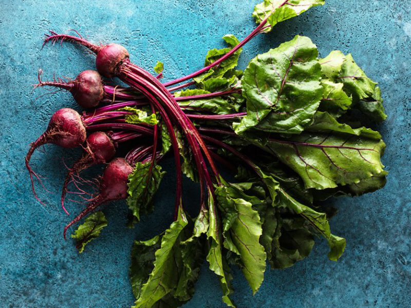 Raw beets on blue background