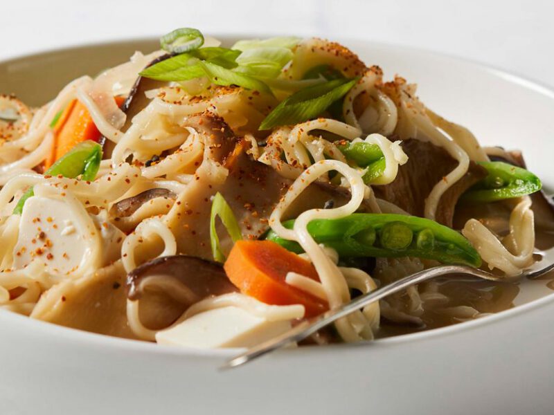 Creamy Vegan Ramen in a white bowl with a metal spoon