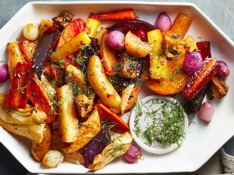 Roasted Root Vegetable Medley on a white serving platter with a side of dipping sauce