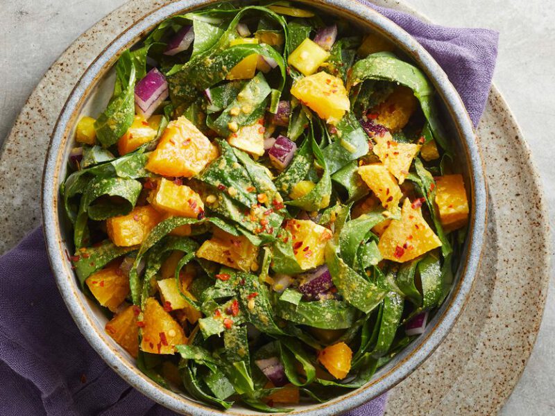 Spicy Collard Slaw in a ceramic bowl on a gray countertop