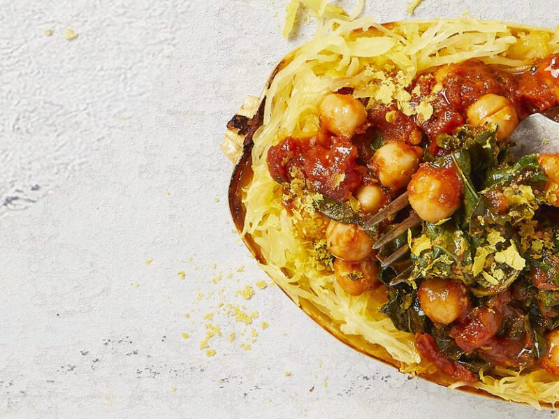 Kale Arrabbiata-Stuffed Spaghetti Squash with a metal fork on a white marble counter