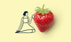 A cartoon woman sitting beside a strawberry