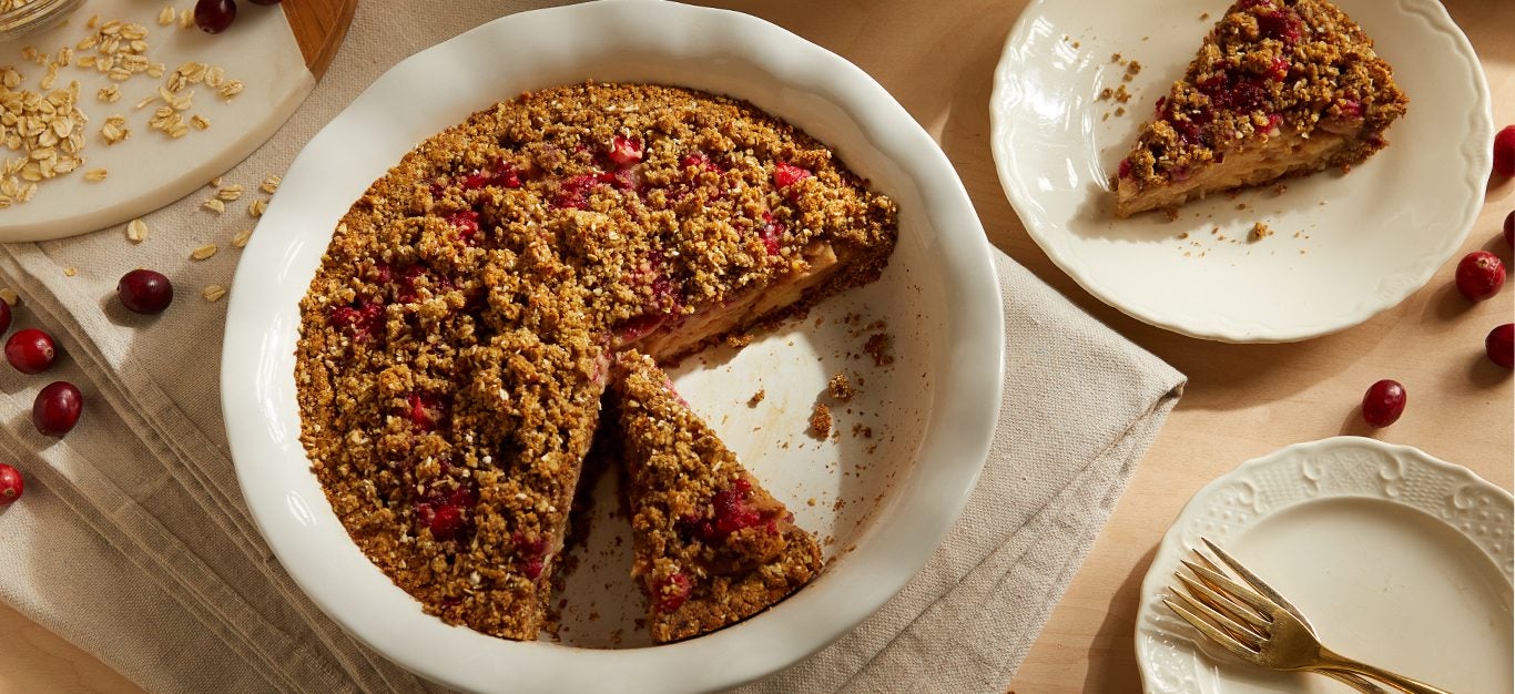 Cranberry-Pear Crumble Pie in a white dish with a slice of pie on the side