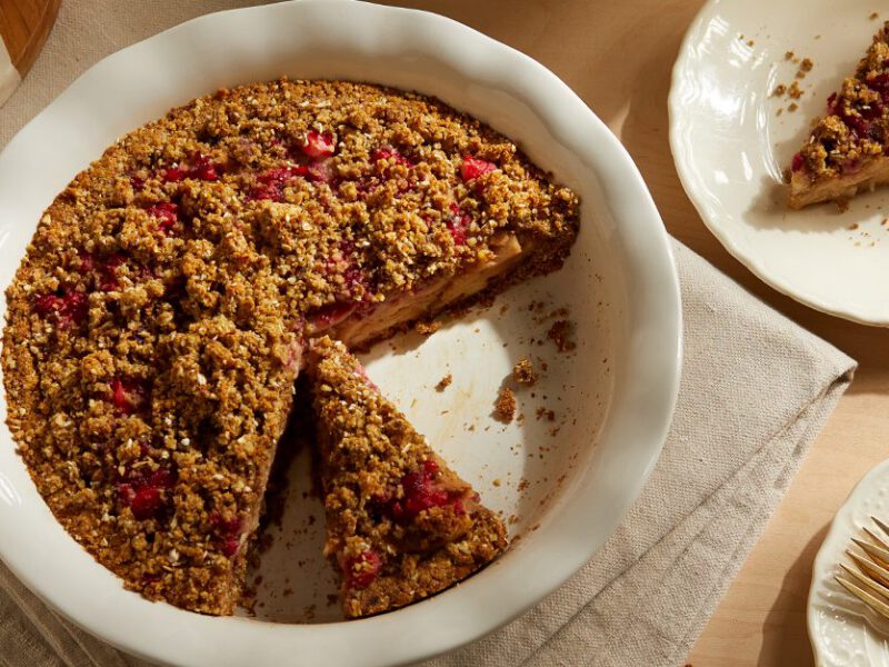 Cranberry-Pear Crumble Pie in a white dish with a slice of pie on the side