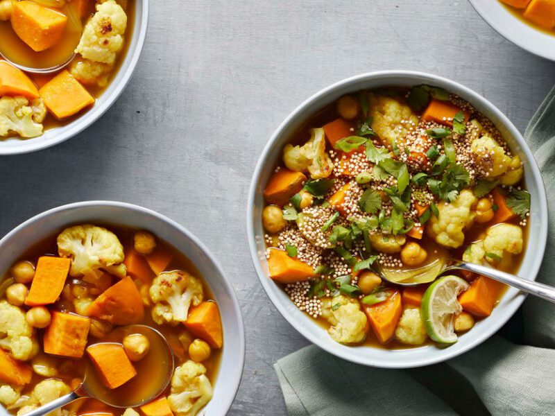 Roasted Cauliflower and Sweet Potato Soup in three bowls on a gray counter
