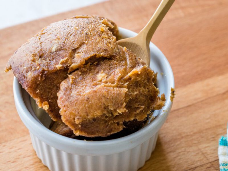 miso paste in a ramekin on a wooden cutting board with a wooden spoon inserted into the paste