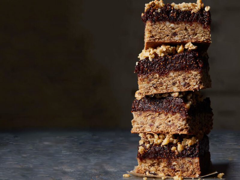 A stack of gluten-free fig bars against a dark background