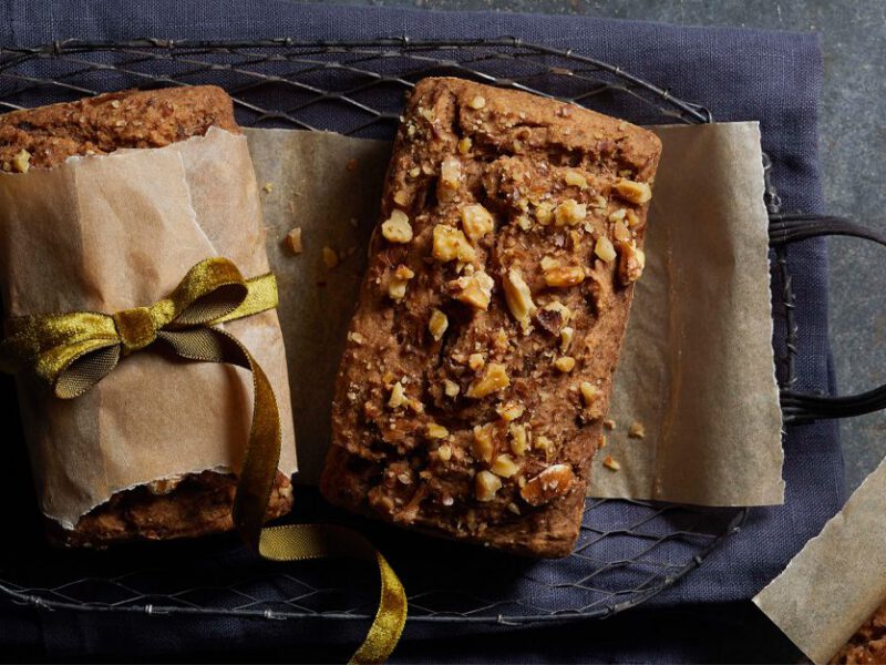 Spelt Banana-Walnut Bread mini loaves wrapped in parchment paper with a green ribbon bow