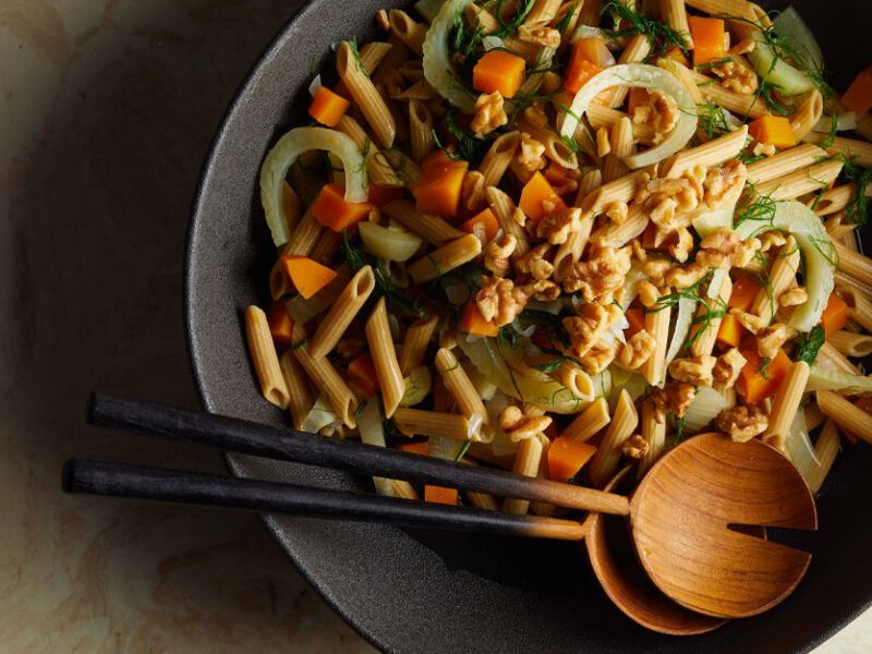 Penne with Butternut Squash and Fresh Fennel in a gray bowl with wooden serving spoons
