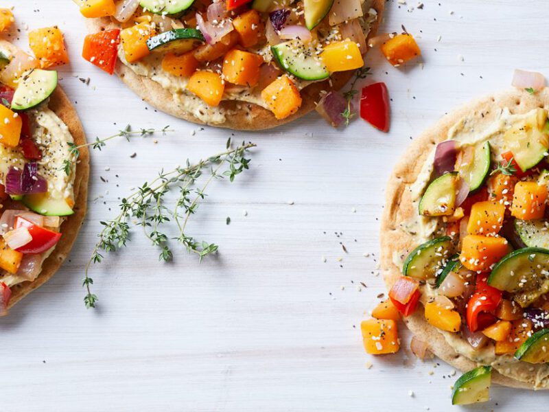 Vegetable Pitas with Everything Spice Hummus on a white table with fresh thyme sprigs