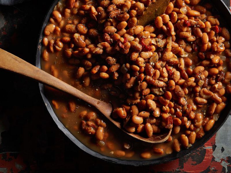Multicooker Pot o’ Beans in a skillet with a wooden spoon