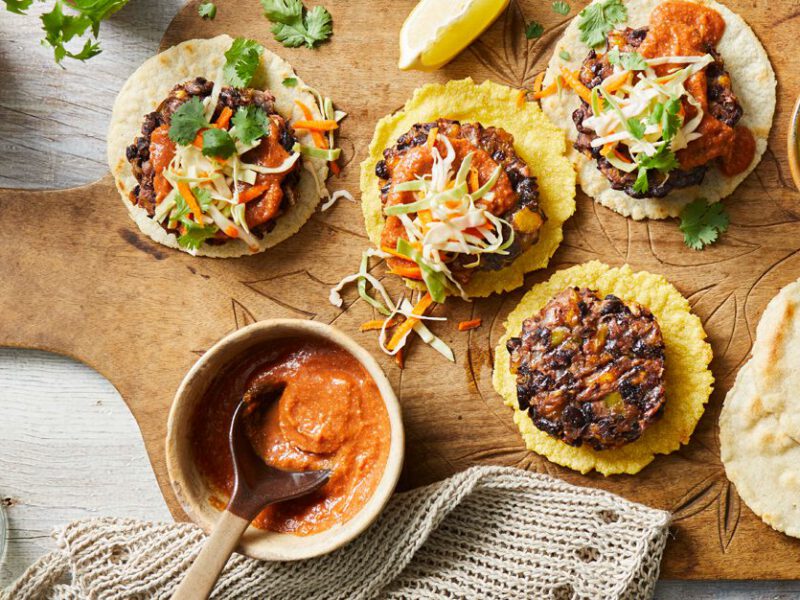 Black Bean and Plantain Burgers with Salvadoran Corn Tortillas on a wood cutting board