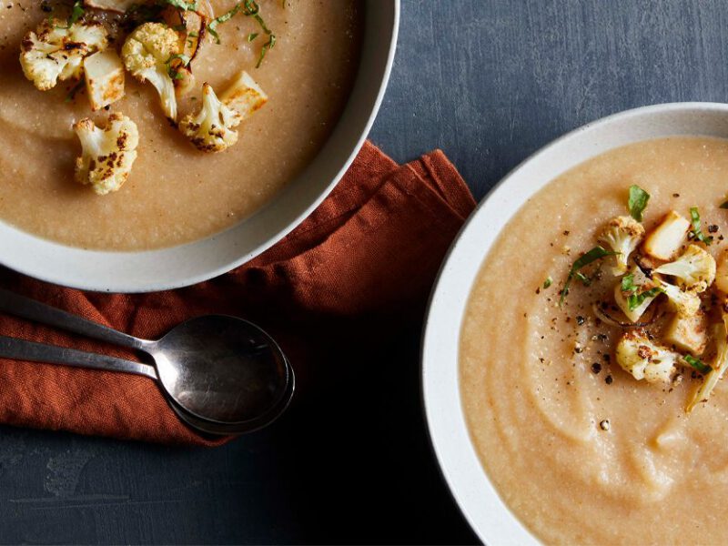 Roasted Cauliflower Soup in white bowls garnished with cauliflower florets