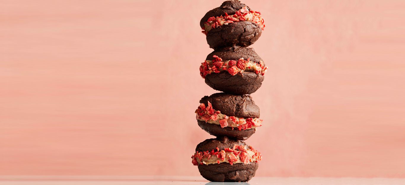 Chocolate-Strawberry Vegan Whoopie Pies in a stack against a pink background