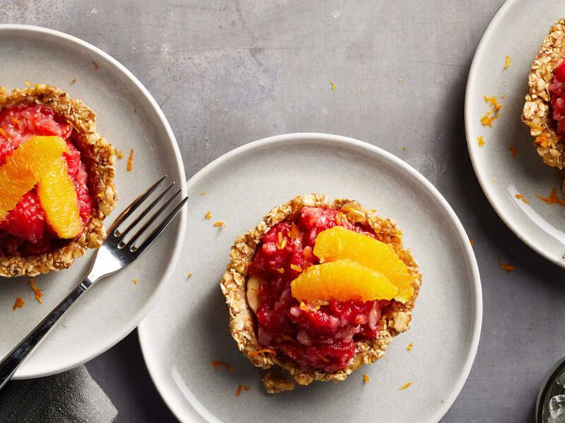 Mixed Fruit Tartlets with Raw Date and Nut Crust on white plates with metal forks