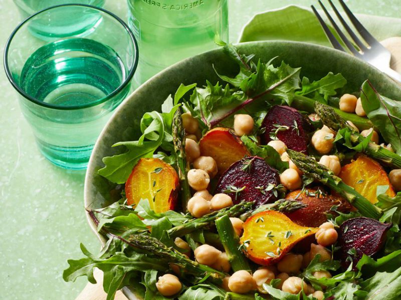 Dandelion Greens Salad with Roasted Baby Beets in a white bowl against a green background