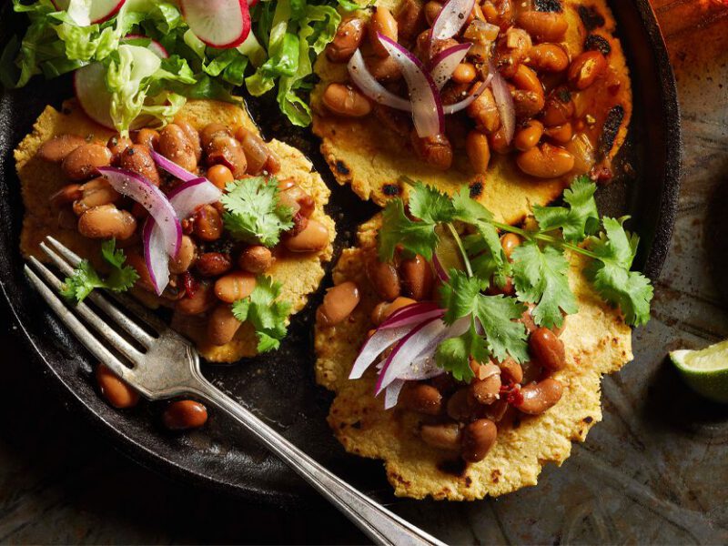 Vegan Bean Gorditas on a black plate with lime wedges