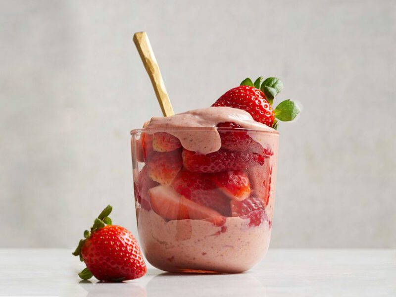 The Best Vegan Strawberries and Cream in a glass cup with gold spoon