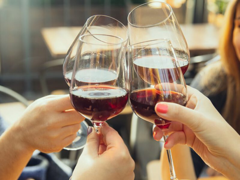 Young people clinking glasses of wine together in cheers