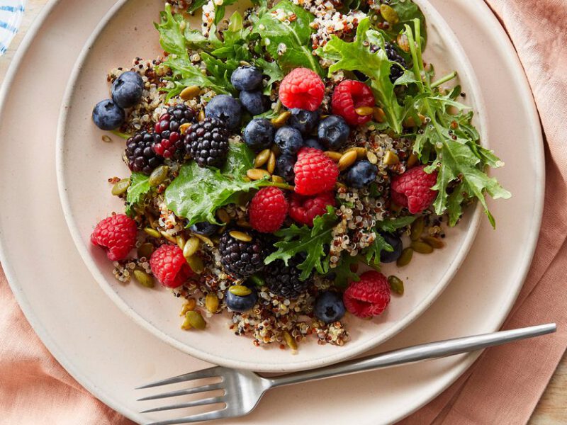 Power Berry Quinoa and Kale Salad on a white plate with a metal fork