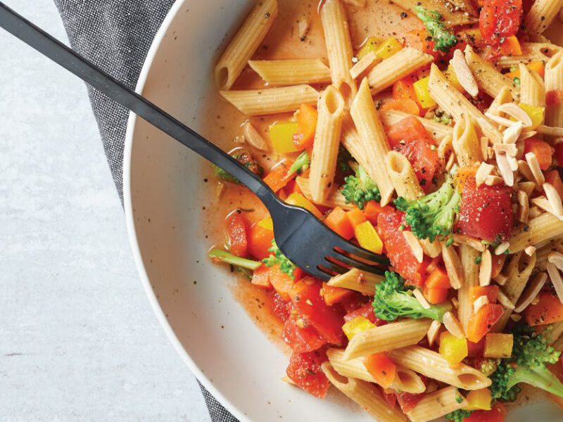 Microwave Pasta Primavera in a white bowl with metal fork