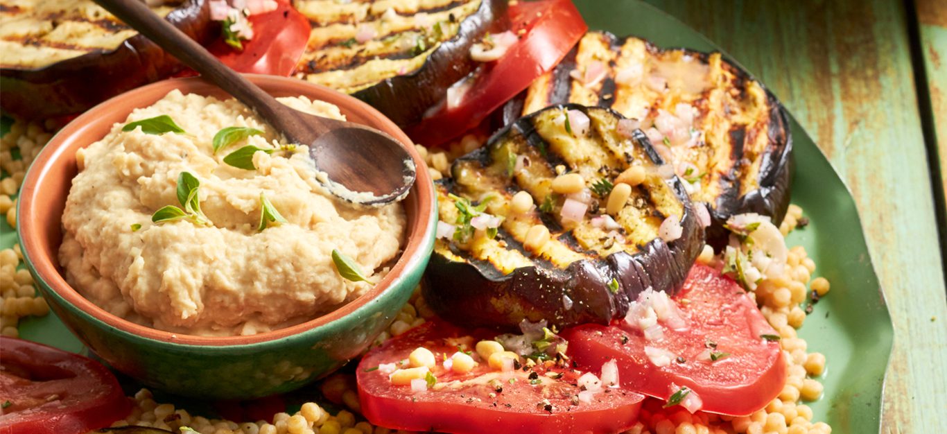 Greek-Style Grilled Eggplant Steak Supper on a platter with a bowl of hummus