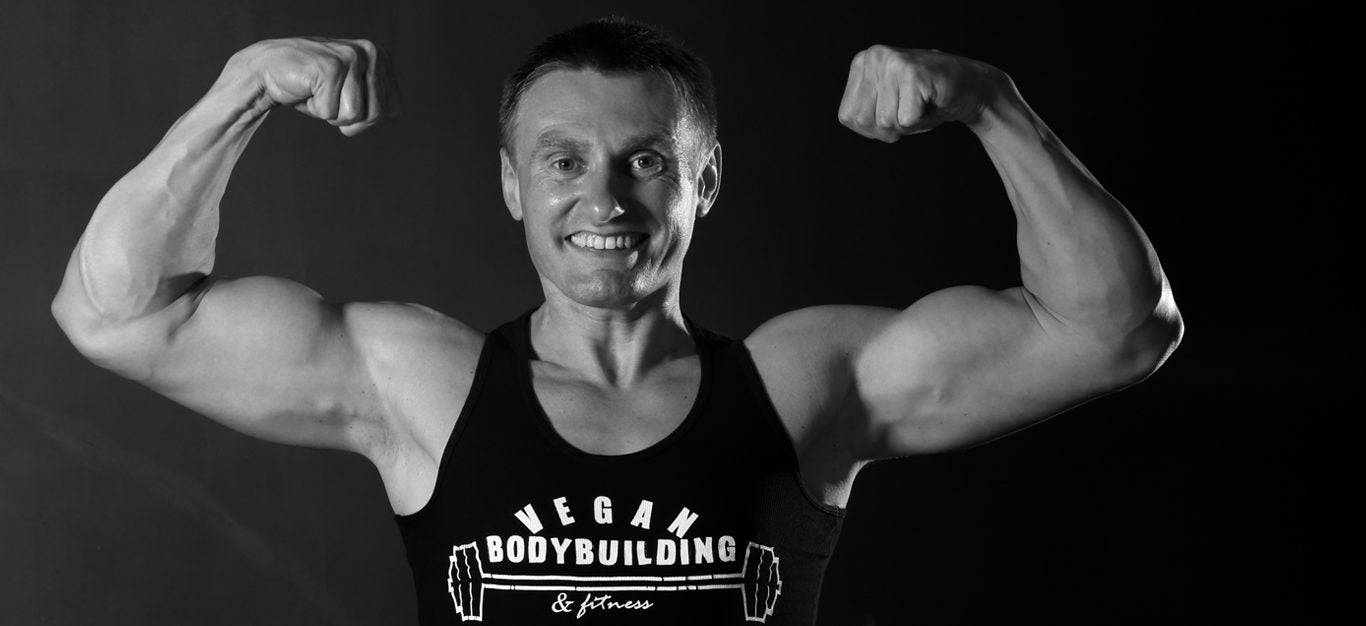 Robert Cheeke flexes in a tank top that reads vegan bodybuilding