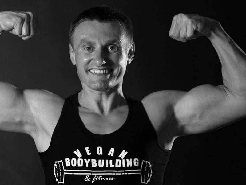 Robert Cheeke flexes in a tank top that reads vegan bodybuilding