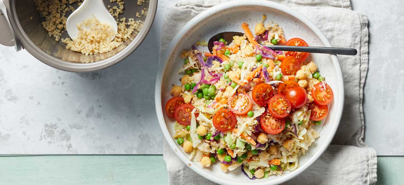 15-Minute Quinoa Slaw Bowl in a white dish with a metal spoon