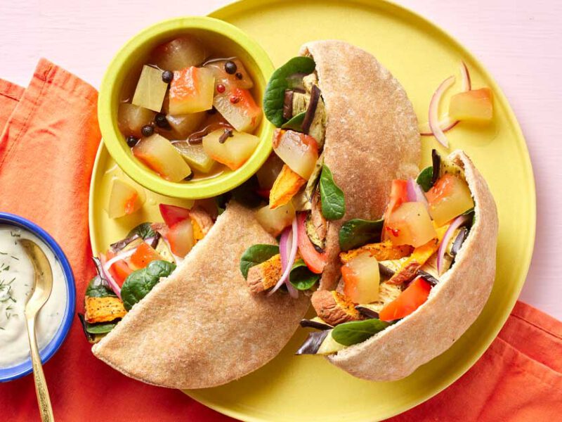 Roasted Eggplant Gyros with Watermelon Rind Pickles on a yellow plate with a bowl of tzatziki sauce