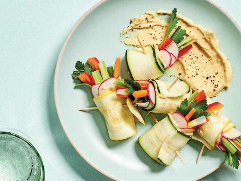Summer Squash Roll-Ups on a light blue plate with clear water glasses