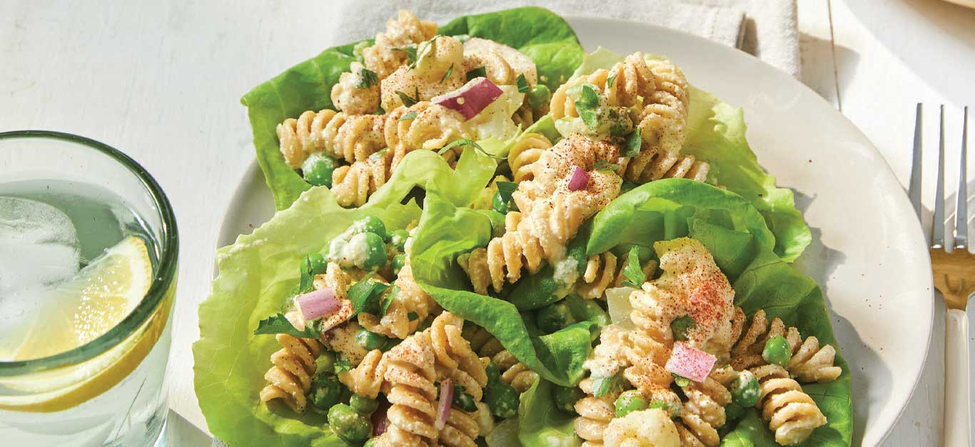 Cauliflower Pasta Salad Wraps in a white dish with a glass of water and metal fork