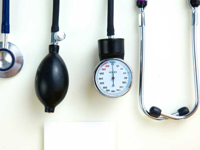 A stethoscope and blood pressure cuff laid out on a white table