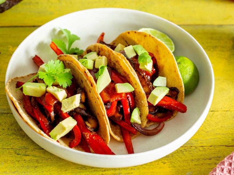 Veggie Fajitas in a white bowl on a yellow table