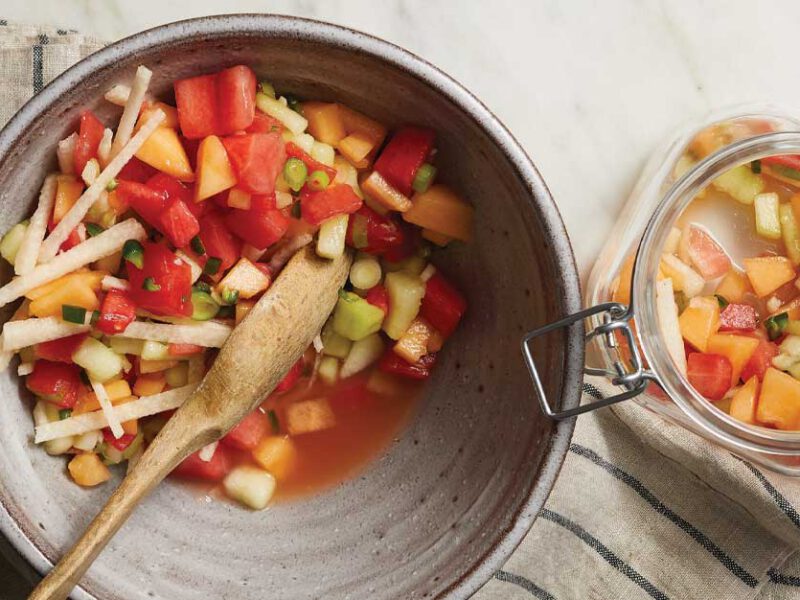 Summer Fruit Salsa with Melons and Jicama in a gray bowl on a striped dishcloth