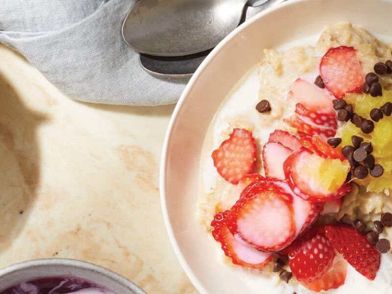 Banana Split Oatmeal Bowls in a white dish with a bowl of strawberries to the left