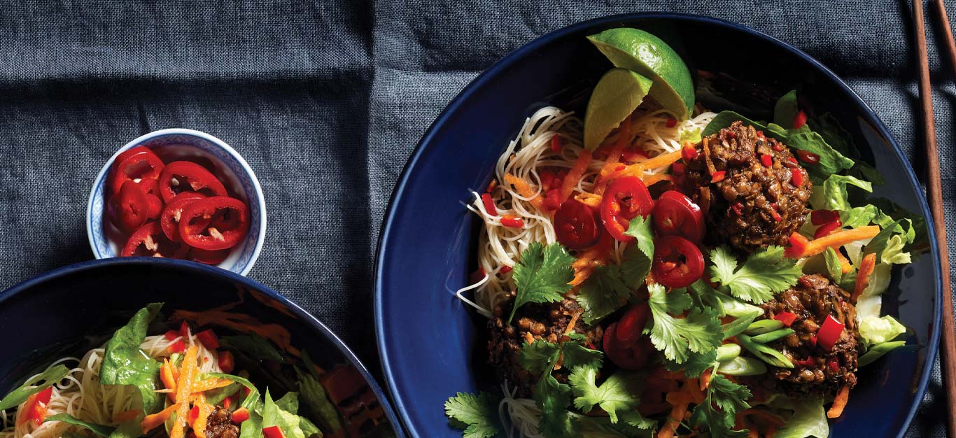 Vietnamese Noodle Bowls with Ginger-Lime Meatballs on dark blue plates against a gray tablecloth