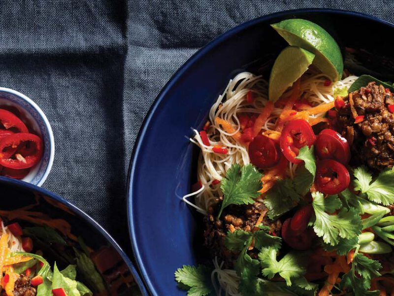 Vietnamese Noodle Bowls with Ginger-Lime Meatballs on dark blue plates against a gray tablecloth