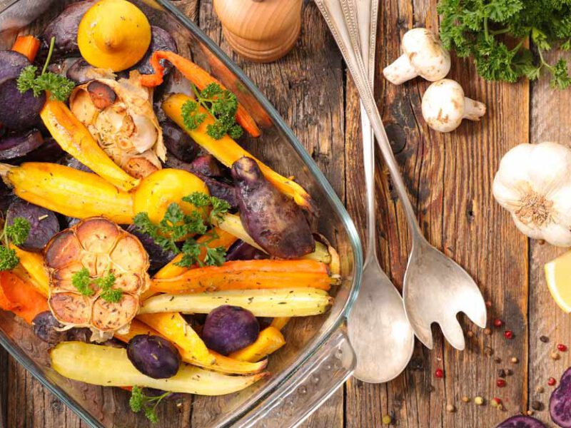 A casserole dish of carrots and other root vegetables roasted without oil