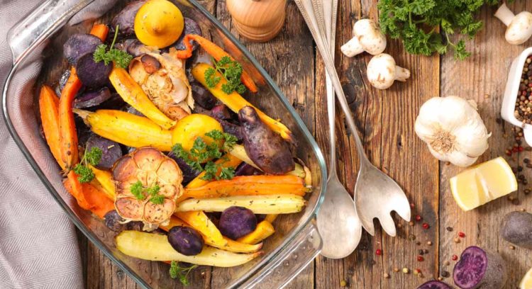 A casserole dish of carrots and other root vegetables roasted without oil