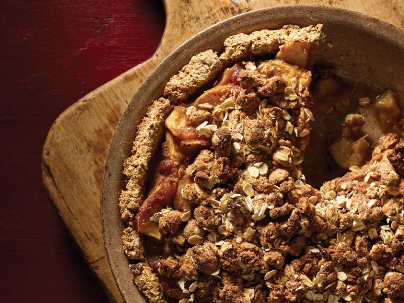 Vegan Apple Pie in a pie tin on a wooden cutting board
