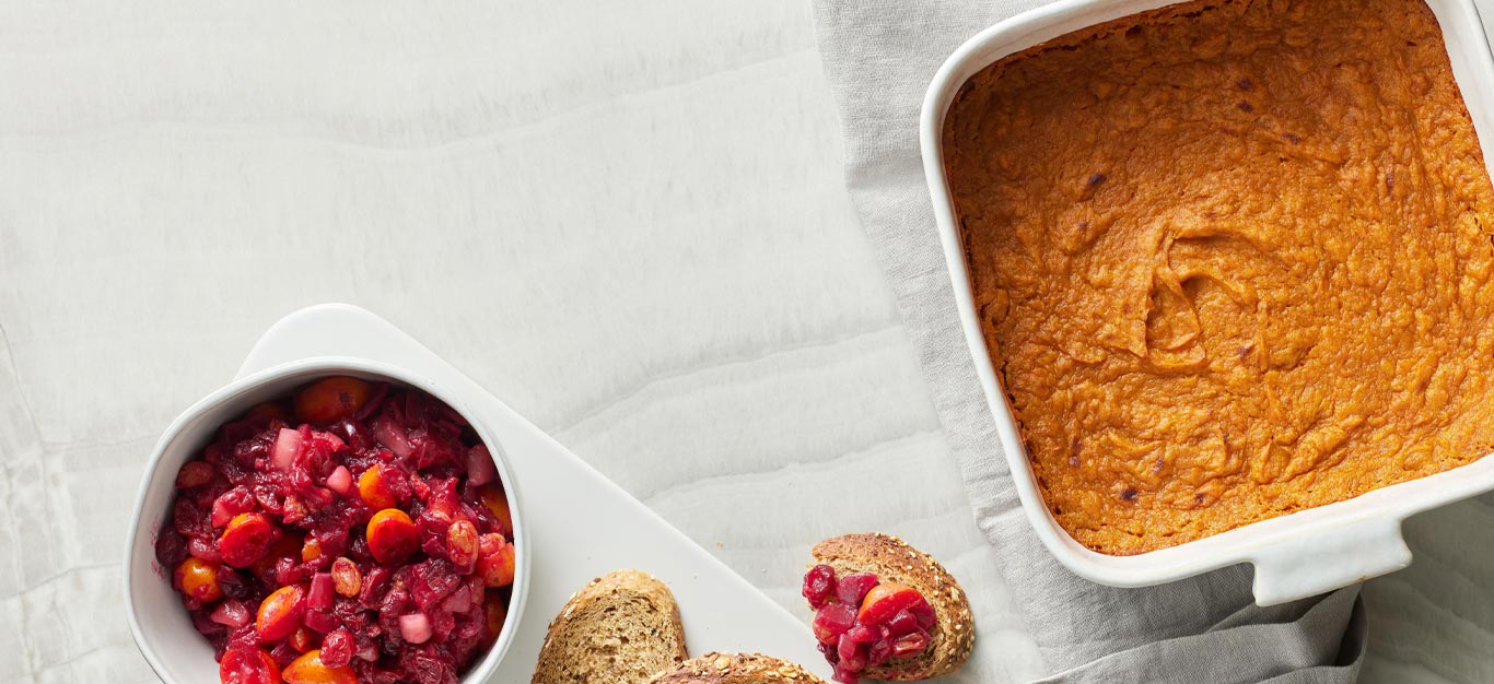 Sweet Potato Spoon Pudding in a casserole dish with a side of cranberry relish