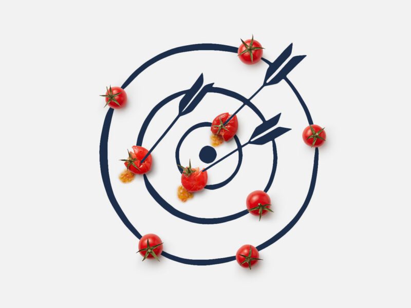 An illustration of a target with three arrows sticking out of it, with the arrows piercing cherry tomatoes