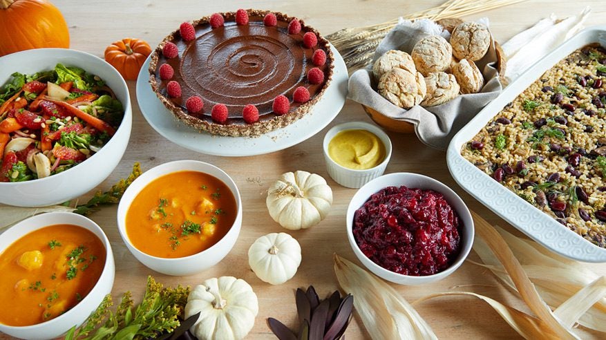 a vegan Thanksgiving tablespread including a rice casserole and chocolate pie and dinner rolls