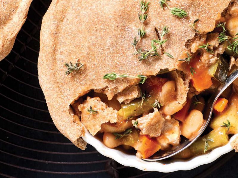 Mini Tuscan Bean Vegan Pot Pies in a white ceramic dish with a metal spoon