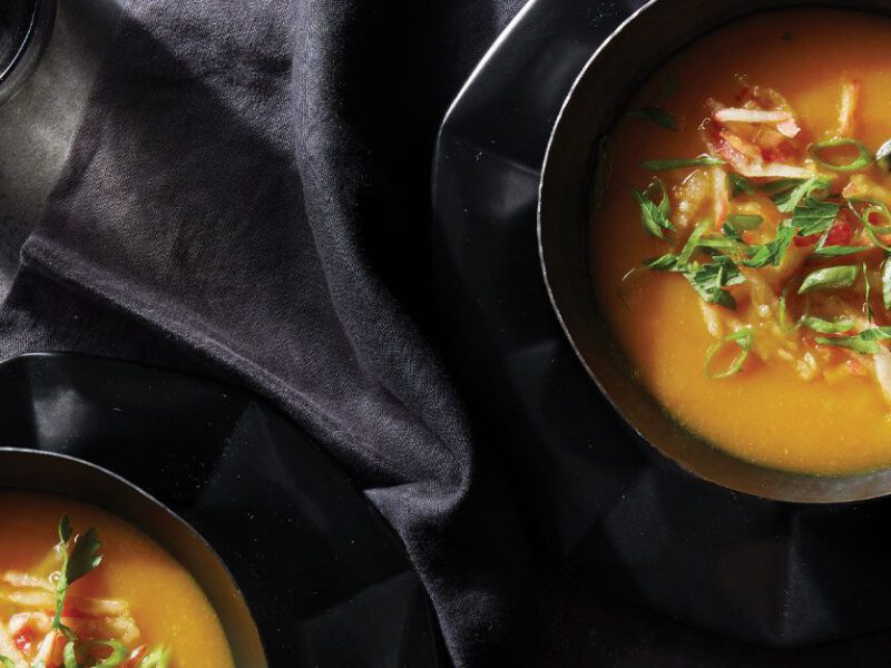 Instant Pot Golden Root Vegetable Soup in black bowls topped with chopped apple and scallions